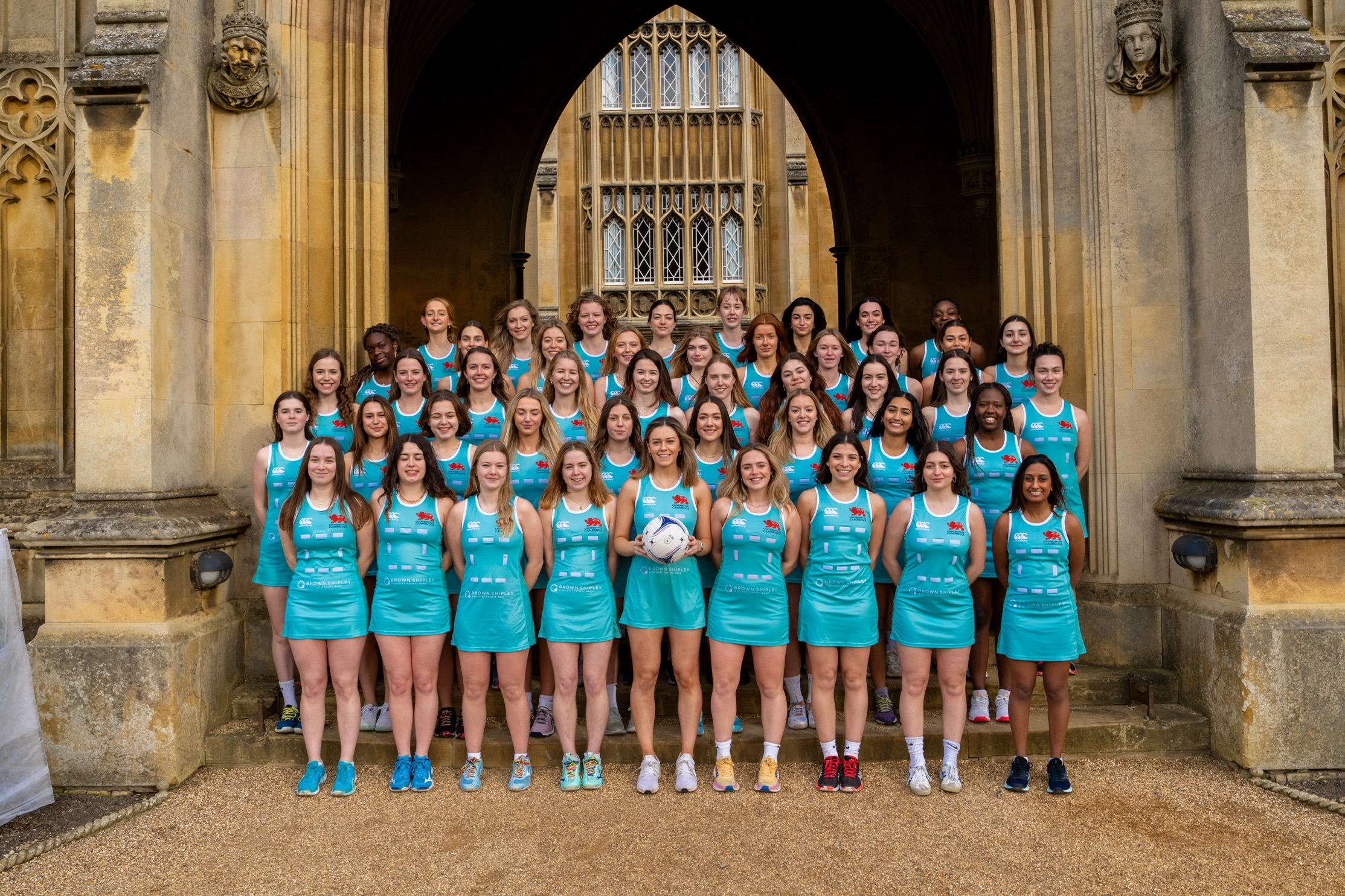 The CULNC club standing with their arms behind their backs in duck egg blue netball dresses, smiling.